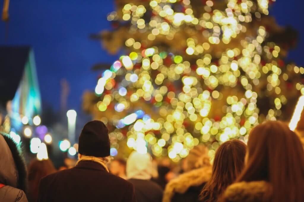 people enjoying Christmas tree with lights on street
